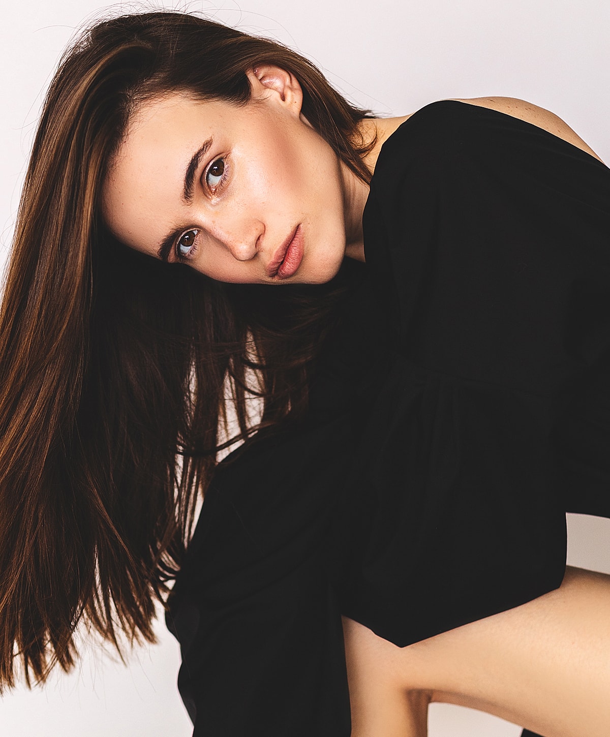 Model in black attire with flowing hair.