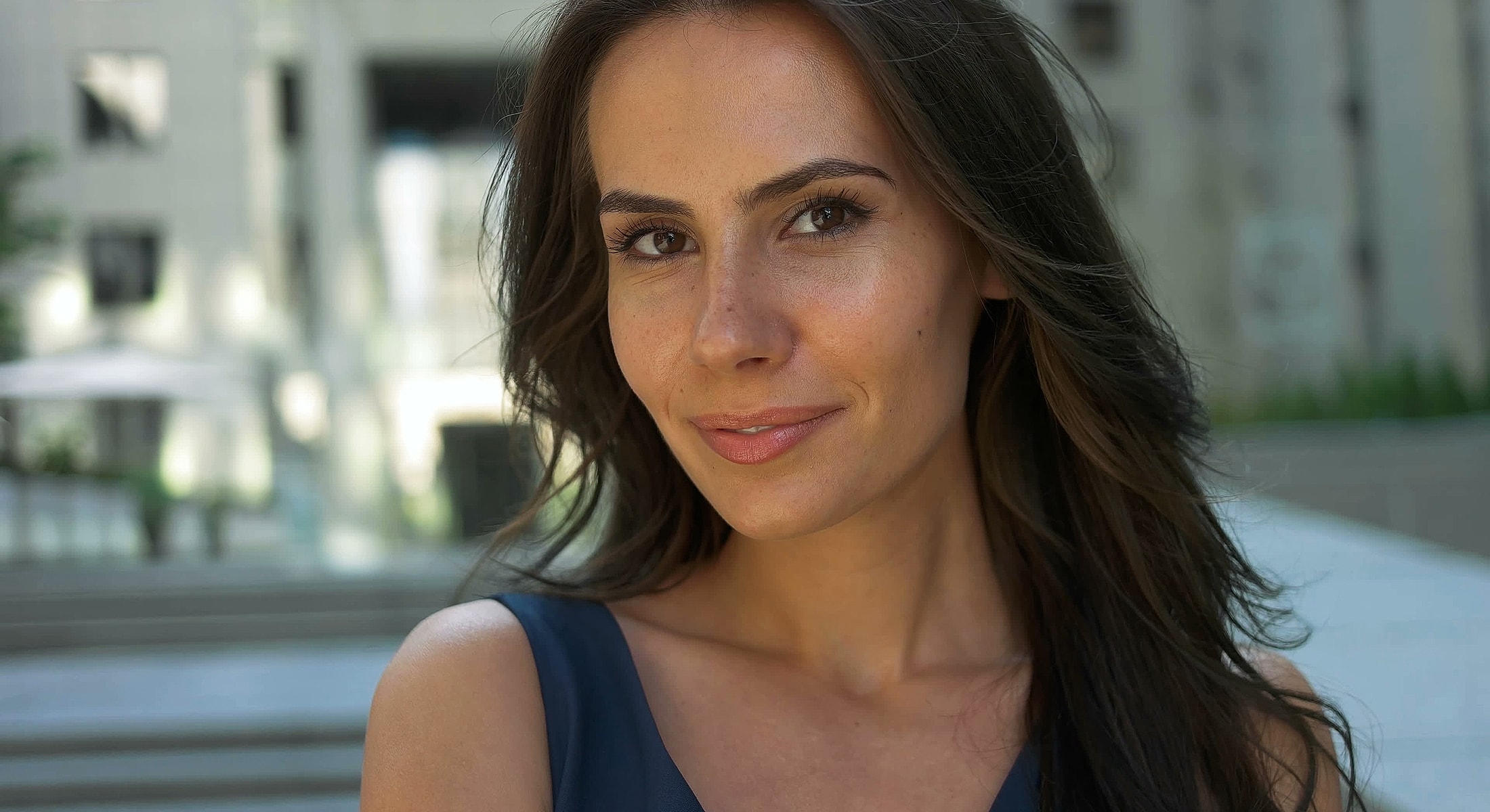 Woman smiling outdoors with natural background.